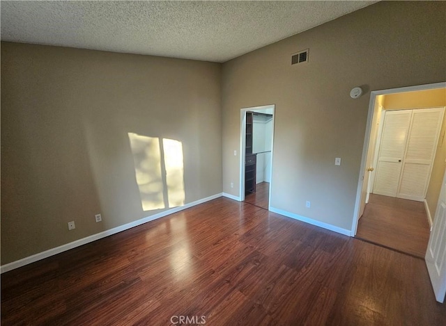 spare room featuring visible vents, baseboards, and wood finished floors