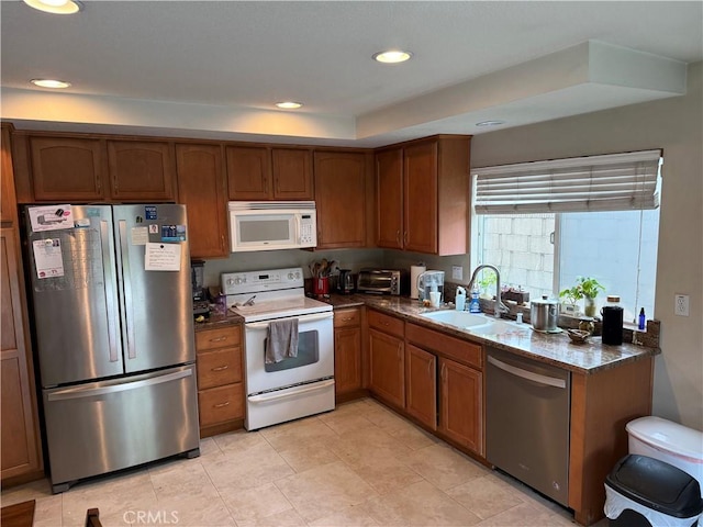 kitchen with a sink, recessed lighting, brown cabinetry, and stainless steel appliances