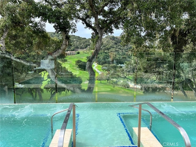 view of swimming pool with view of golf course