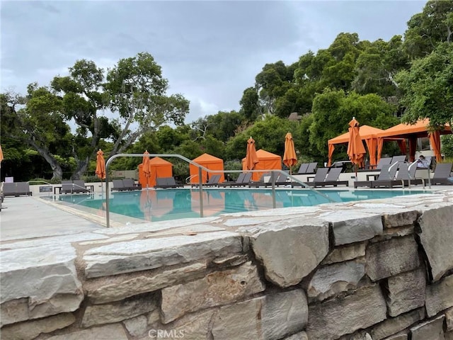 pool with a gazebo, a water play area, and a patio area