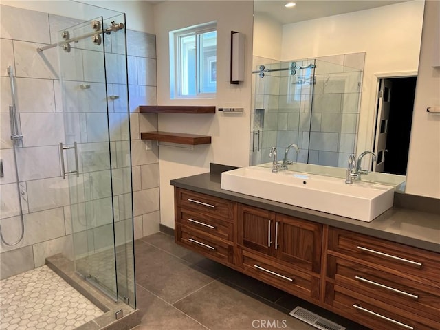 full bath featuring vanity, tile patterned floors, visible vents, and a stall shower