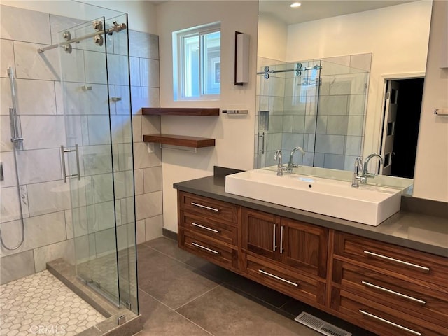 full bathroom featuring visible vents, a shower stall, tile patterned flooring, and vanity