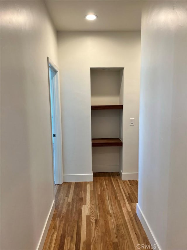 hall featuring recessed lighting, baseboards, and wood finished floors