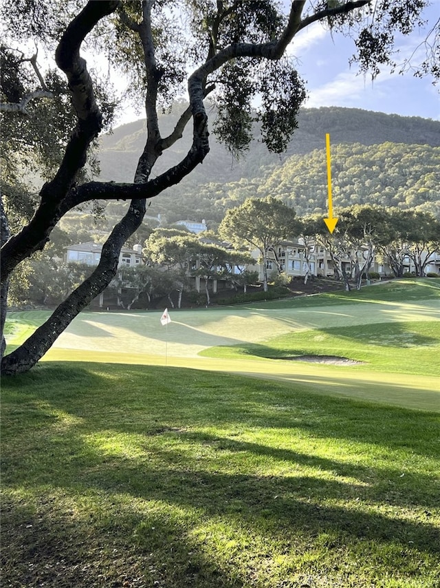 view of home's community featuring a lawn and view of golf course