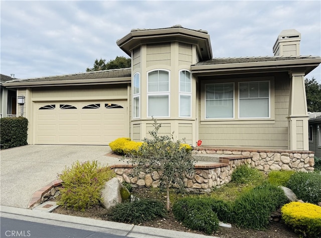 view of front of property with a garage, driveway, and a chimney