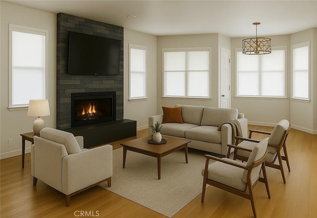 living area with baseboards, light wood-style floors, and a brick fireplace