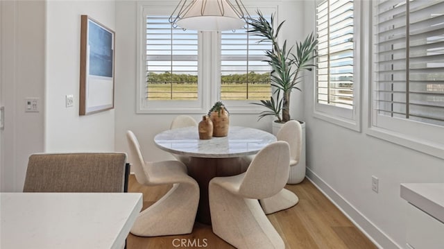 dining area featuring light wood-type flooring and baseboards