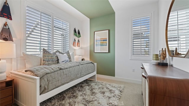 bedroom with multiple windows, baseboards, and carpet floors