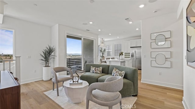 living area featuring recessed lighting, light wood-type flooring, and baseboards