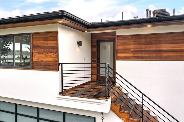 entrance to property with a balcony and stucco siding