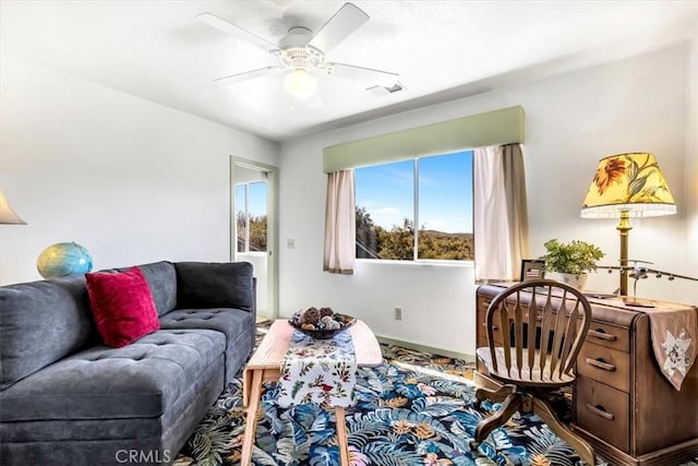 living area featuring visible vents, baseboards, and a ceiling fan