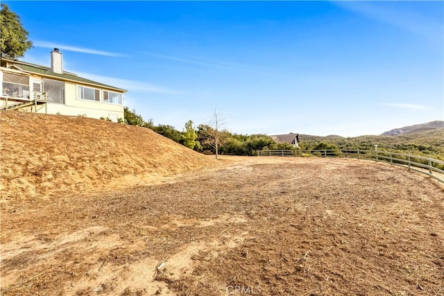 view of yard featuring a mountain view and fence