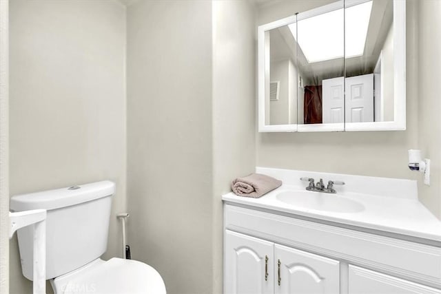 bathroom featuring visible vents, toilet, and vanity