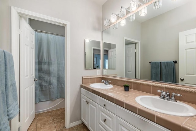 bathroom featuring double vanity, shower / tub combo with curtain, and a sink