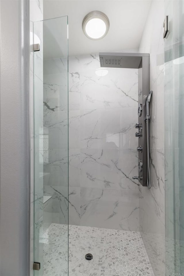 full bathroom with a marble finish shower