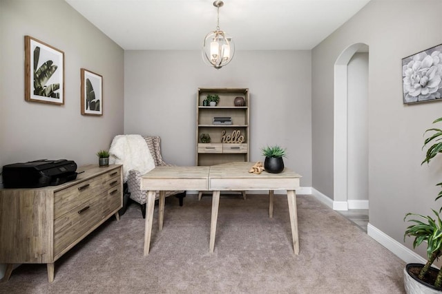 office space with arched walkways, baseboards, and carpet floors