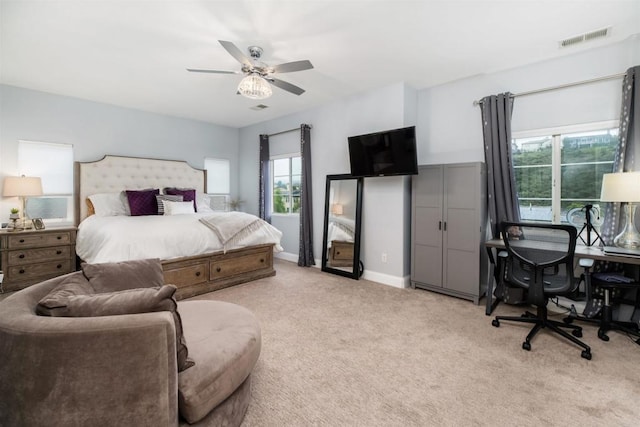 carpeted bedroom with visible vents, baseboards, and a ceiling fan