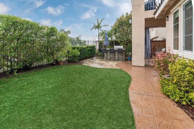 view of yard with a patio area, fence, and outdoor dry bar