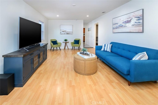 living room with recessed lighting, visible vents, and light wood finished floors