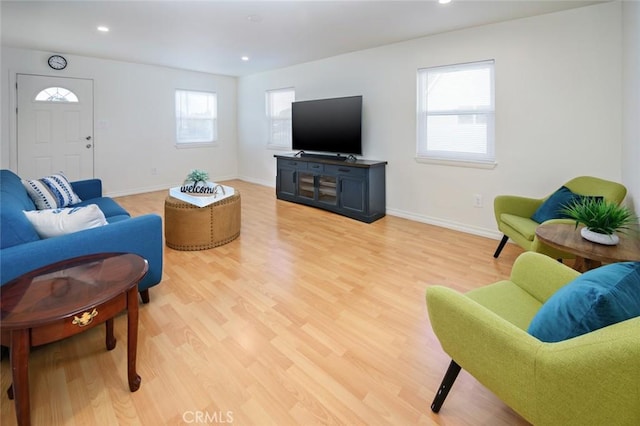 living room featuring recessed lighting, baseboards, and light wood-style flooring