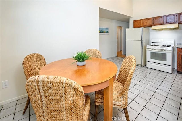 dining space with light tile patterned floors and baseboards