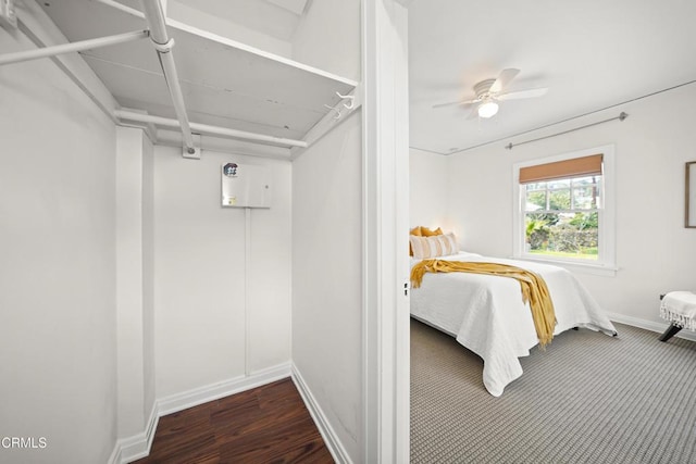 bedroom featuring baseboards, wood finished floors, and a ceiling fan