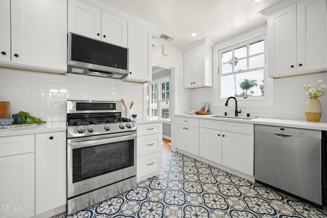 kitchen featuring visible vents, a sink, light countertops, appliances with stainless steel finishes, and white cabinetry