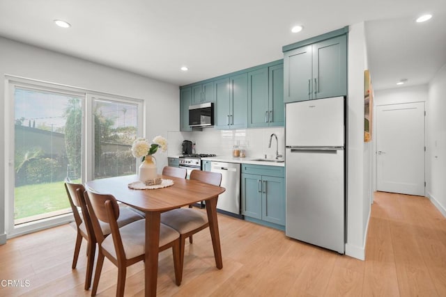 kitchen featuring a sink, stainless steel appliances, a wealth of natural light, and light wood-style flooring