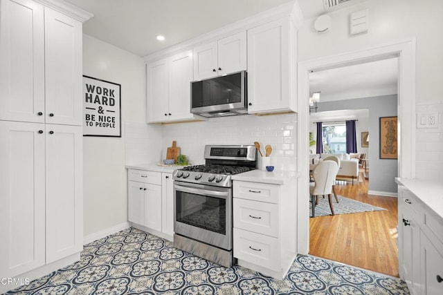 kitchen with white cabinetry, light countertops, and appliances with stainless steel finishes