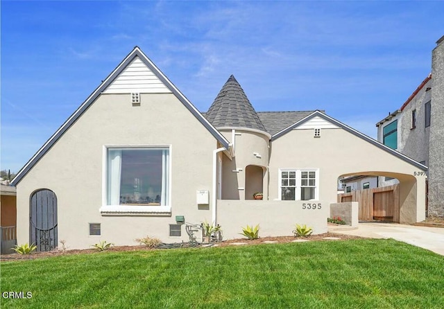 view of front of home featuring stucco siding, a shingled roof, a front yard, and fence