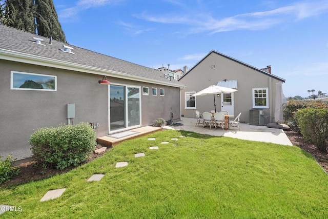 back of property featuring stucco siding, central air condition unit, a lawn, a patio, and a shingled roof