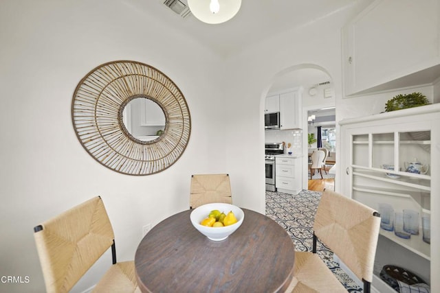 dining room featuring visible vents and arched walkways