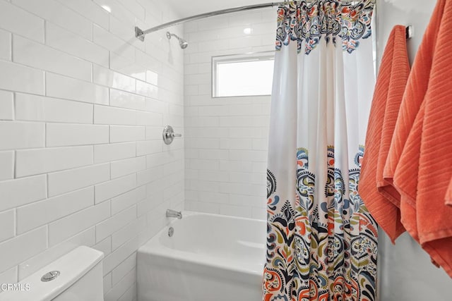 bathroom with toilet and shower / tub combo with curtain