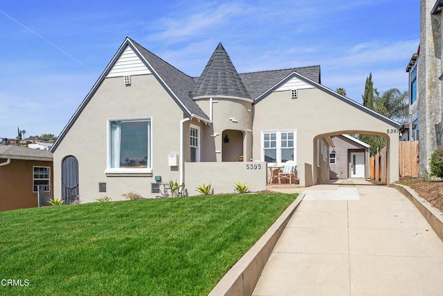 view of front of property featuring stucco siding, a shingled roof, a front yard, and fence