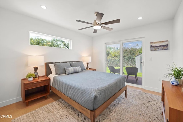 bedroom featuring light wood finished floors, multiple windows, and access to outside