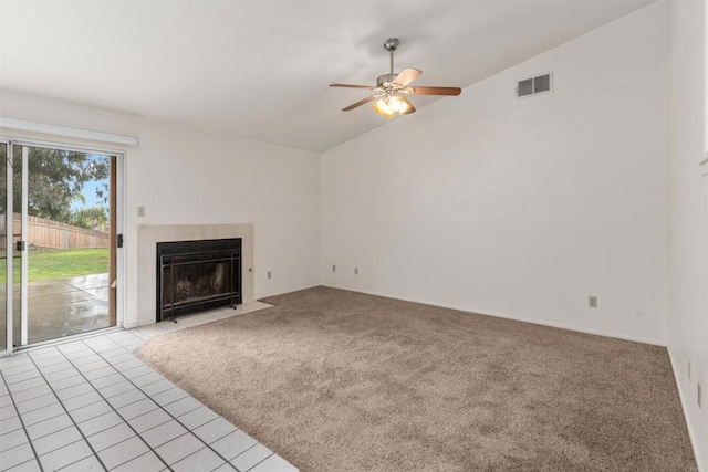 unfurnished living room featuring visible vents, lofted ceiling, a fireplace with flush hearth, ceiling fan, and light carpet