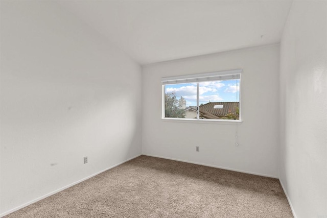 spare room with lofted ceiling, baseboards, and carpet floors