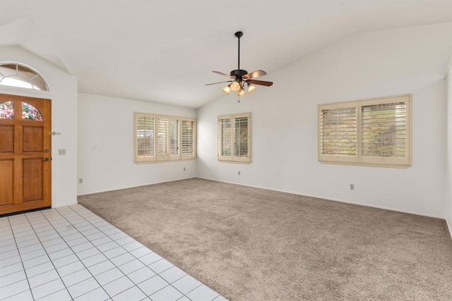 entrance foyer with vaulted ceiling, light tile patterned floors, light colored carpet, and ceiling fan