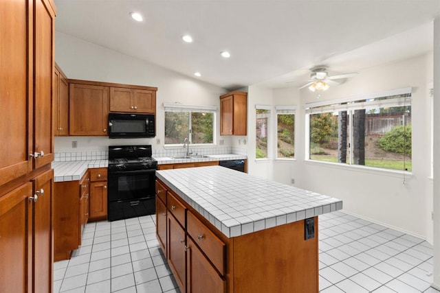 kitchen with brown cabinets, black appliances, a sink, tile countertops, and light tile patterned floors