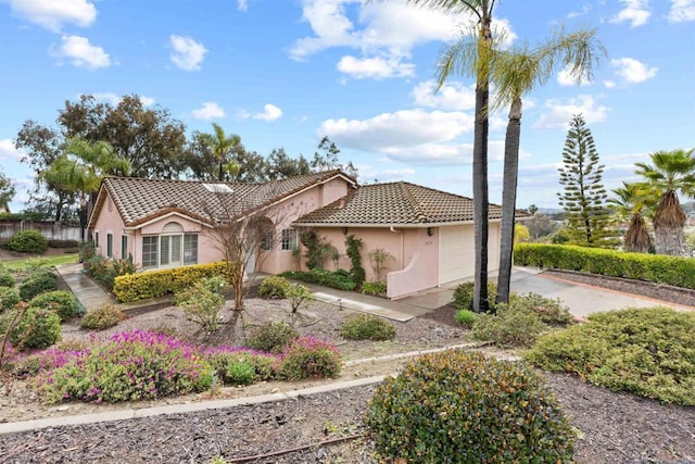 view of front of house with a tiled roof, stucco siding, driveway, and an attached garage