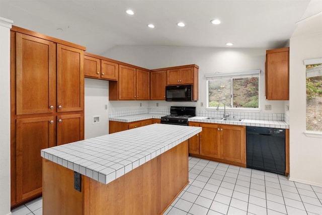 kitchen featuring a sink, brown cabinets, black appliances, and tile counters