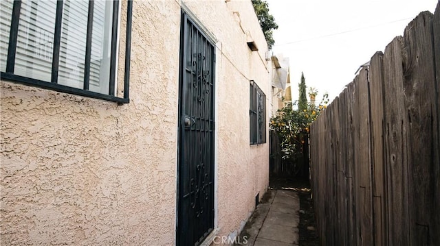 view of home's exterior featuring stucco siding and fence