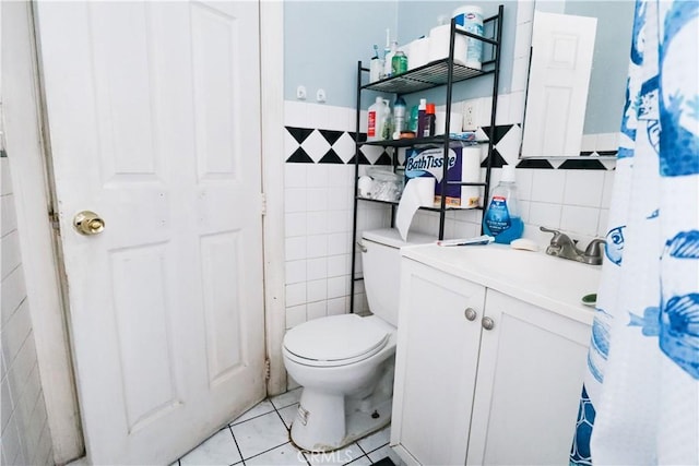 bathroom featuring vanity, tile patterned floors, toilet, and tile walls