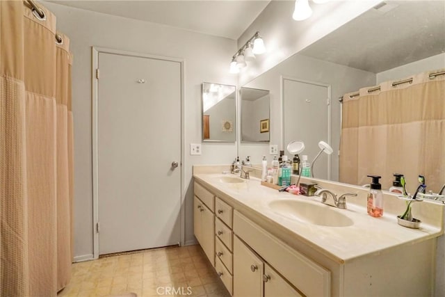 bathroom featuring double vanity, tile patterned floors, and a sink