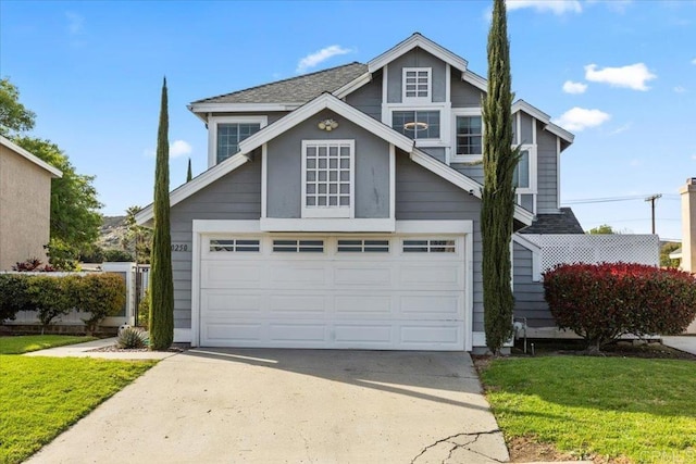 view of front of home with a front lawn, an attached garage, and driveway