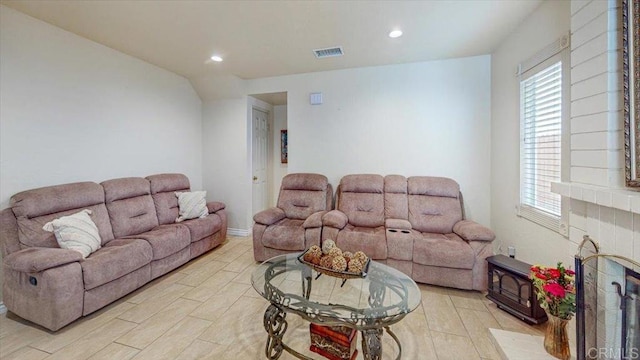 living room featuring recessed lighting, plenty of natural light, a fireplace, and visible vents