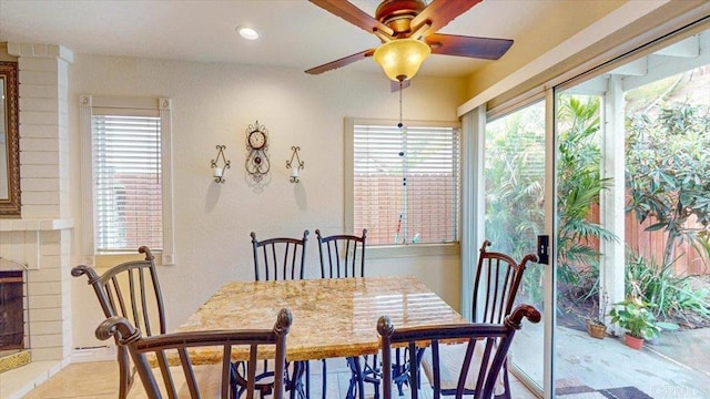 dining room featuring recessed lighting, a fireplace, and a ceiling fan