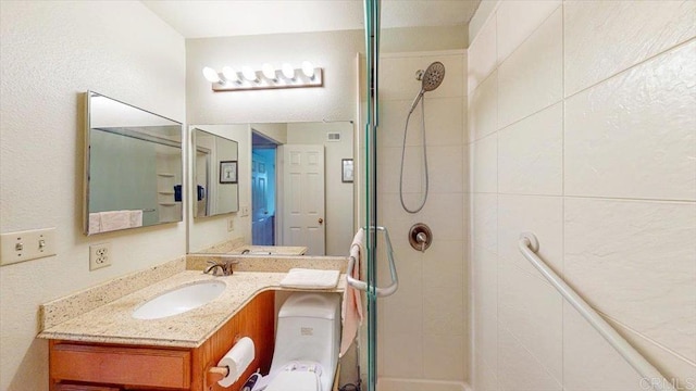 full bath featuring a tile shower and vanity