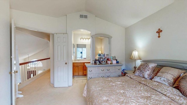 bedroom featuring arched walkways, light colored carpet, multiple windows, and vaulted ceiling