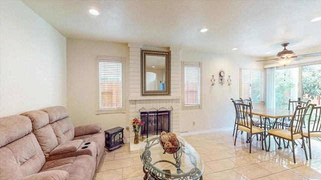 dining area featuring a brick fireplace, baseboards, a textured ceiling, and a healthy amount of sunlight